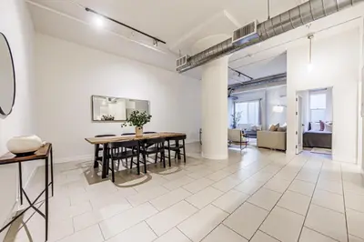 a living room with a table and a couch at Industrial Style 2BR Condo Downtown LA With Rooftop! in Los Angeles
