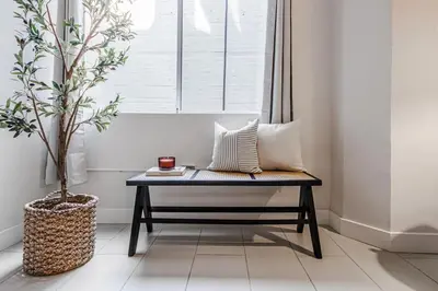 a bench with pillows on it in a room with a window at Industrial Style 2BR Condo Downtown LA With Rooftop! in Los Angeles