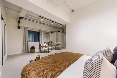 a bedroom with a bed and a living room at Modern Loft 1BR in Downtown LA! in Los Angeles