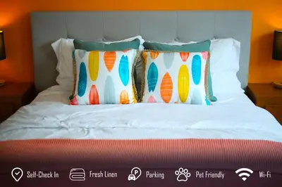 a bed with four pillows on top of it at 6BR 3BA Home near Disneyland in Anaheim