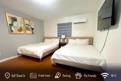 a room with two beds and a flat screen tv at 6BR 3BA Home near Disneyland in Anaheim