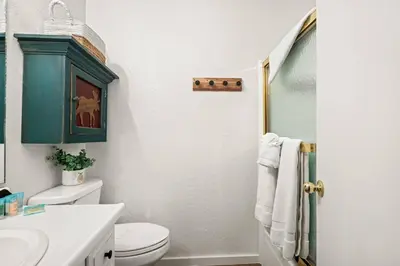 a bathroom with a toilet and a blue cabinet at Summit Slope Side in Big Bear Lake