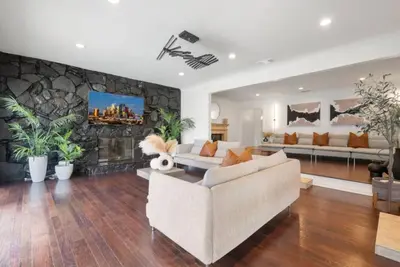 a living room with a couch and a stone wall at Blue Haven Solar Pool Heat Parking Billiards in Long Beach