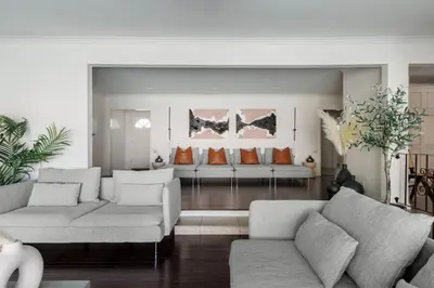 a living room with two white couches and orange pillows at Blue Haven Solar Pool Heat Parking Billiards in Long Beach