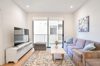 a living room with a couch and a tv at Pacific Pearl 2 bed Apt with FREE PARKING in Santa Monica in Los Angeles