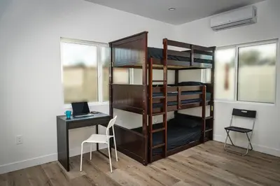 a room with a bunk bed and a desk and a computer at Riverton Place NoHo in Los Angeles
