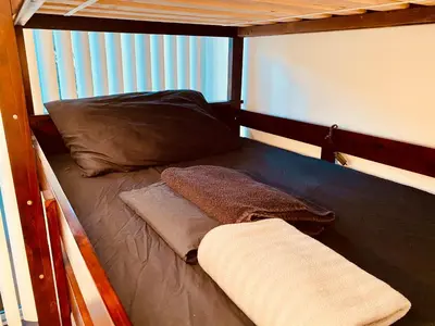 a bunk bed with a pillow and a towel on it at Riverton Place NoHo in Los Angeles