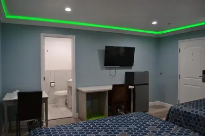 a bedroom with a green lighting on the wall at Villa Las Palmas Motel in Barton Heliport