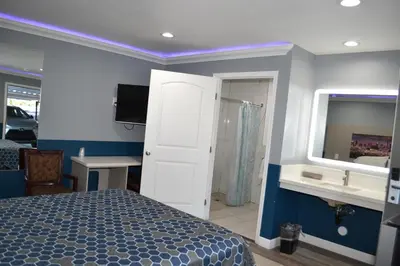 a bedroom with a bed and a bathroom with a mirror at Villa Las Palmas Motel in Barton Heliport