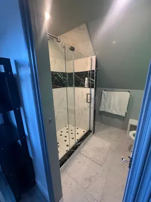 a shower with a glass door in a bathroom at Luxury Master Bedroom with private bathroom walking distance to Sofi Stadium, KIA Forum and Intuit Dome also only train stop away from LAX airport Perfect place for tourists and event attendees in Inglewood