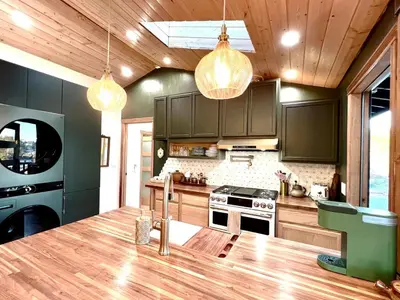 a kitchen with black cabinets and a counter top at The Perch- Hilltop Bungalow, Eagle Rock-near DTLA in Los Angeles