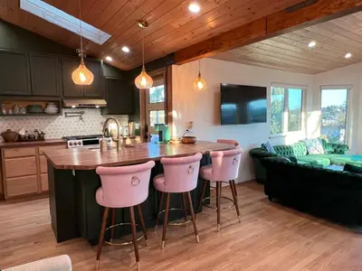 a kitchen with a large island with pink bar stools at The Perch- Hilltop Bungalow, Eagle Rock-near DTLA in Los Angeles