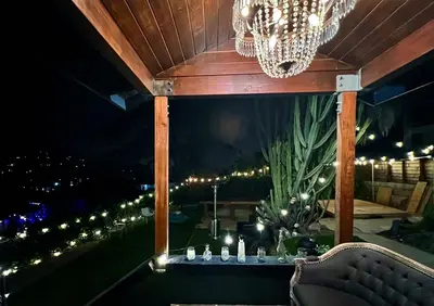 a chandelier and a table on a balcony at night at The Perch- Hilltop Bungalow, Eagle Rock-near DTLA in Los Angeles