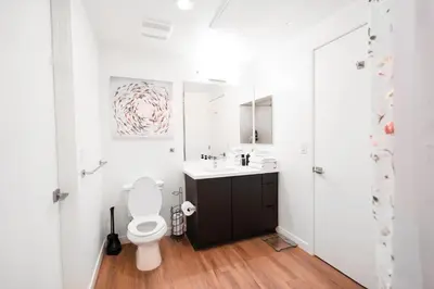 a white bathroom with a toilet and a sink at The Hollywood Highline 2 bed Apt WITH FREE PARKING in Hollywood in Los Angeles