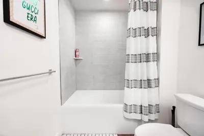a white bathroom with a shower curtain and a toilet at The Hollywood Highline 2 bed Apt WITH FREE PARKING in Hollywood in Los Angeles