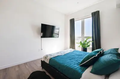 a bedroom with a bed with blue sheets and a window at The Hollywood Highline 2 bed Apt WITH FREE PARKING in Hollywood in Los Angeles