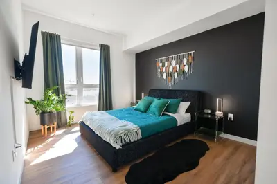 a bedroom with a king sized bed with blue sheets at The Hollywood Highline 2 bed Apt WITH FREE PARKING in Hollywood in Los Angeles