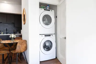 a laundry room with a washer and dryer next to a table at The Hollywood Highline 2 bed Apt WITH FREE PARKING in Hollywood in Los Angeles