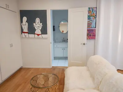 a living room with a couch and a mirror at Venice Canals & Beach Guest Suite in Los Angeles