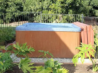 a hot tub with a blue top in a garden at Romantic and Relaxing Villa Retreat with a Jacuzzi near Somis, California in Somis