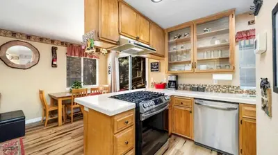 a kitchen with wooden cabinets and a stove top oven at Charming Cabin for Winter and Water Sports Fans Near Big Bear Lake, California in Arrowbear Lake