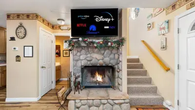 a living room with a fireplace with a tv above it at Charming Cabin for Winter and Water Sports Fans Near Big Bear Lake, California in Arrowbear Lake