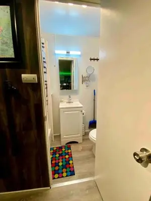 a bathroom with a sink and a toilet and a mirror at Fully Refurbished Container in Devore Heights, California, for Glamping Trips on Route 66 in Devore Heights