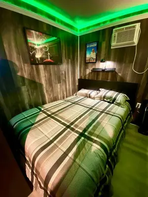 a bedroom with a bed with a green light at Fully Refurbished Container in Devore Heights, California, for Glamping Trips on Route 66 in Devore Heights
