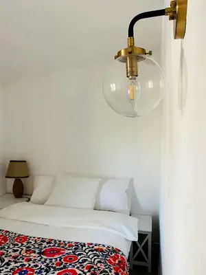 a bedroom with a bed with a lamp on the wall at Stunning Cabin with Indoor Jacuzzi Ideal for a Weekend Getaway from Los Angeles in Pine Mountain Club
