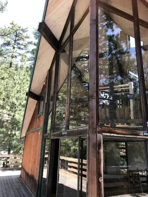 a building with large glass windows on the side of it at Stunning Cabin with Indoor Jacuzzi Ideal for a Weekend Getaway from Los Angeles in Pine Mountain Club