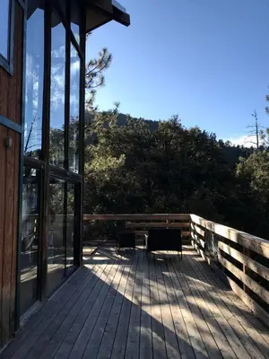 a wooden deck with a bench on the side of a building at Stunning Cabin with Indoor Jacuzzi Ideal for a Weekend Getaway from Los Angeles in Pine Mountain Club