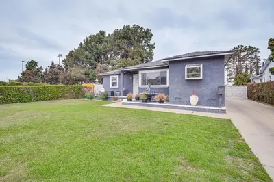 a blue house with a yard at 8 Mi to Dtwn Home with Fireplace and Games in LA! in Los Angeles
