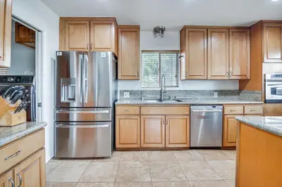 a kitchen with wooden cabinets and stainless steel appliances at 8 Mi to Dtwn Home with Fireplace and Games in LA! in Los Angeles