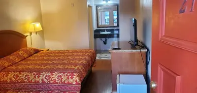 a hotel room with a bed and a television at El Rio Motel in Glendale