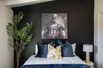 a bedroom with a bed with a painting on the wall at Avengers HQ - Hot Tub - Close to Disney - Parking in Anaheim