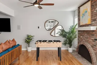 a living room with a table in front of a fireplace at Splash Haven-Heated Pool-Huge Living Area-Sleeps 8 in Long Beach