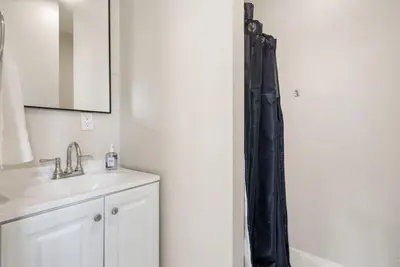 a bathroom with a sink and a black shower curtain at Sunset Shores - Near the beach - Games - Sleeps 8 in Long Beach
