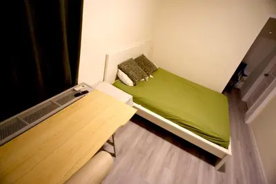 a small room with a green bed and a table at Walk of Fame 1 Bedroom with shared bathroom and kitchen in Los Angeles