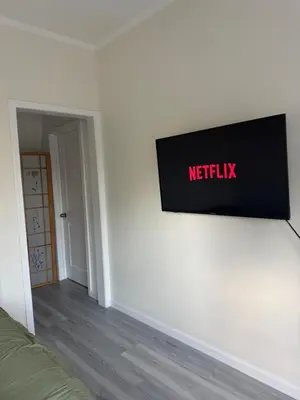 a television on a wall in a room at Walk of Fame 1 Bedroom with shared bathroom and kitchen in Los Angeles
