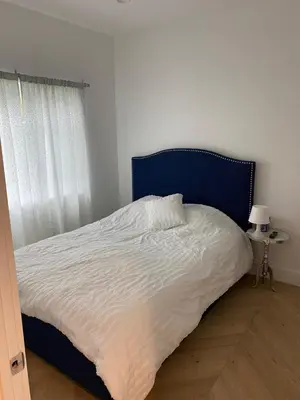 a bed with a blue headboard in a bedroom at Guest House in Los Angeles