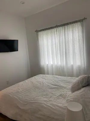 a bedroom with a white bed and a window at Guest House in Los Angeles