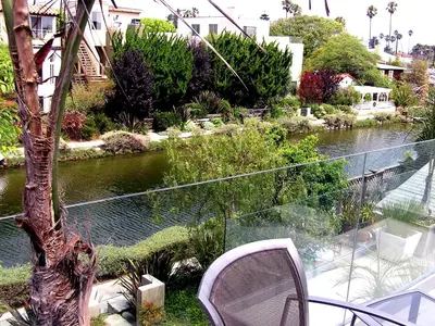 a balcony with a table and chairs and a river at Venice Canals Contemporary, unique wildlife, amazing reviews in Los Angeles