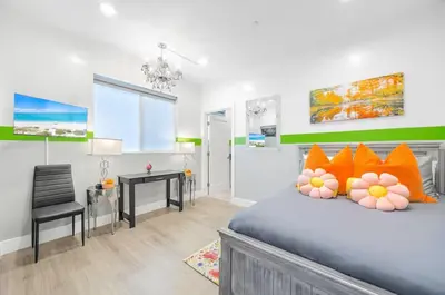 a bedroom with a bed with orange pillows and a desk at B- InstaWorthy & Family-Friendly NoHo Gem- Near Universal & Hollywood with Parking, Games, and Hot Tub in North Hollywood