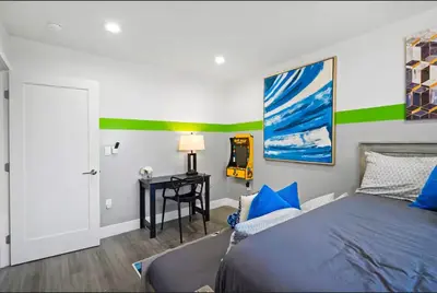 a bedroom with a bed and a desk and a painting at C- Vibrant and Glam NoHo Pad near U-Studios and H-Sign in North Hollywood