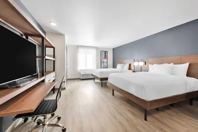 a hotel room with a large bed and a flat screen tv at Everhome Suites San Bernardino - Loma Linda in San Bernardino