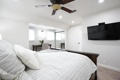 a bedroom with a bed and a flat screen tv at Sensational 6 Bedroom 4 Bathroom Pool Home (3 Master Bedrooms W/bathrooms) in Anaheim