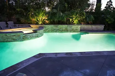 a swimming pool in a backyard at night at Sensational 6 Bedroom 4 Bathroom Pool Home (3 Master Bedrooms W/bathrooms) in Anaheim