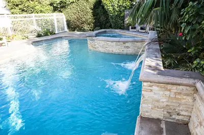 a swimming pool with a waterfall in a yard at Sensational 6 Bedroom 4 Bathroom Pool Home (3 Master Bedrooms W/bathrooms) in Anaheim