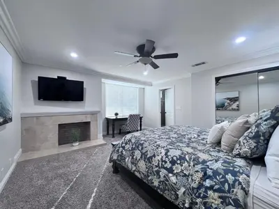 a bedroom with a bed and a flat screen tv at Sensational 6 Bedroom 4 Bathroom Pool Home (3 Master Bedrooms W/bathrooms) in Anaheim