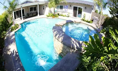 a swimming pool in front of a house at Highly Upgraded, 5 Bed, 45 ba, New Pool w/Jacuzzi, 1/2 mile walk to Disney in Anaheim